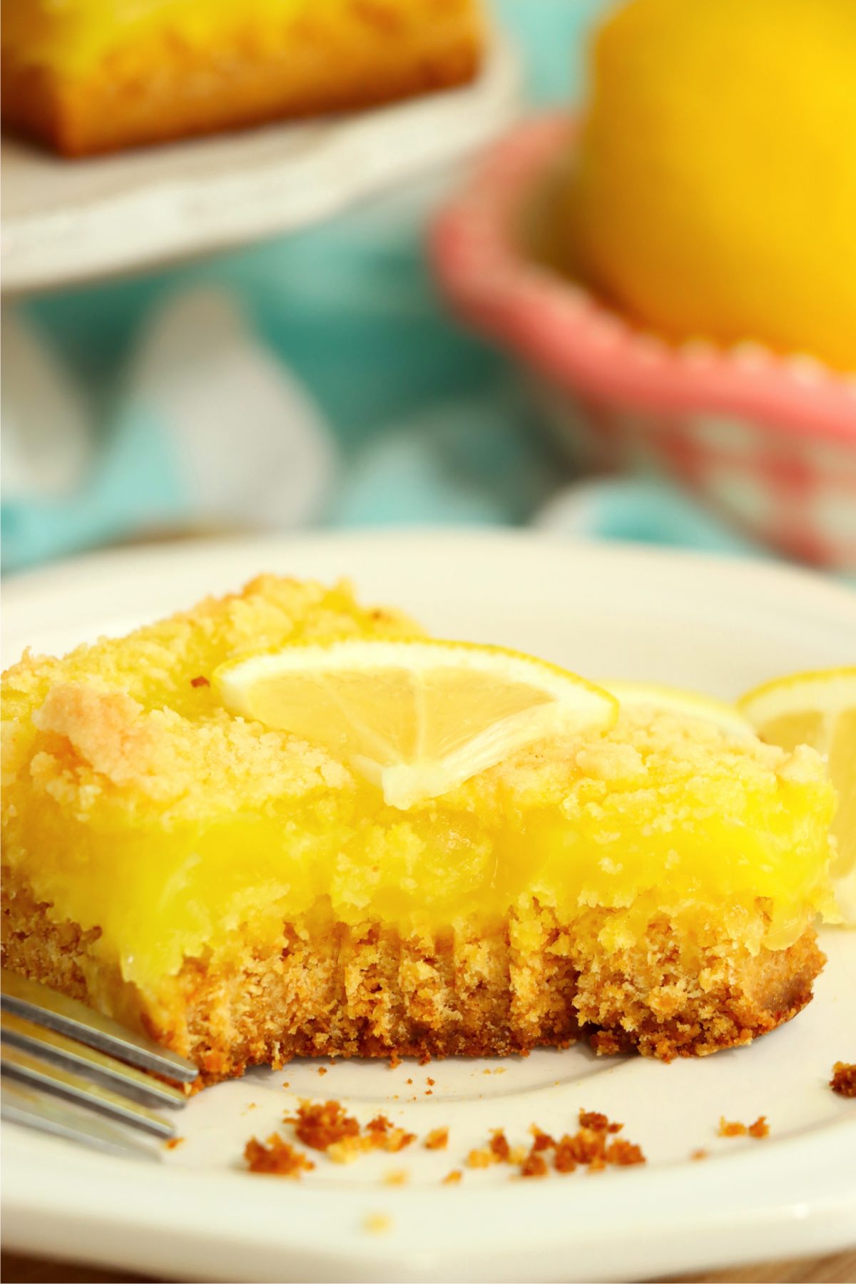 bite out of lemon bar on a white plate