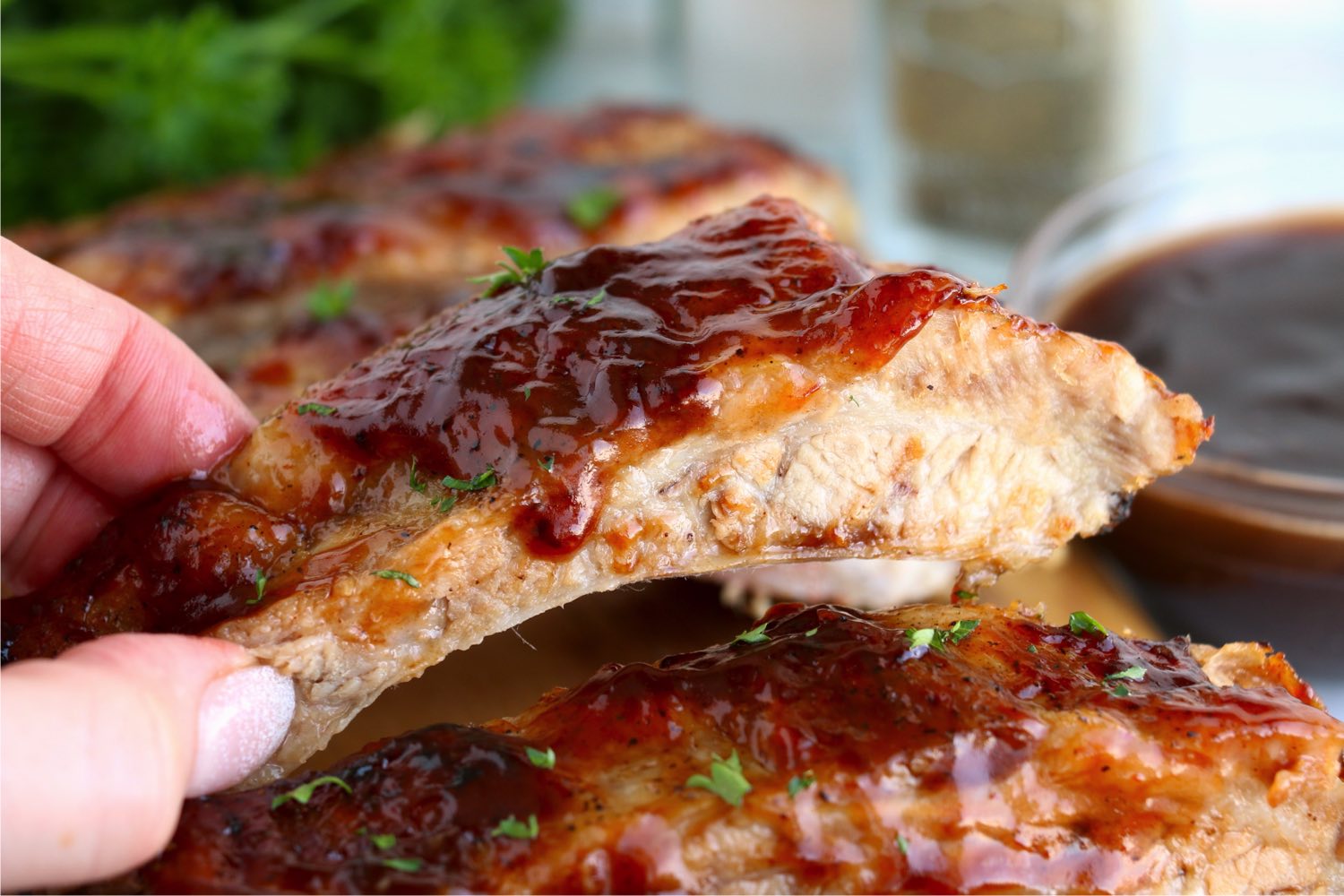 hand holding up a saucy riblet