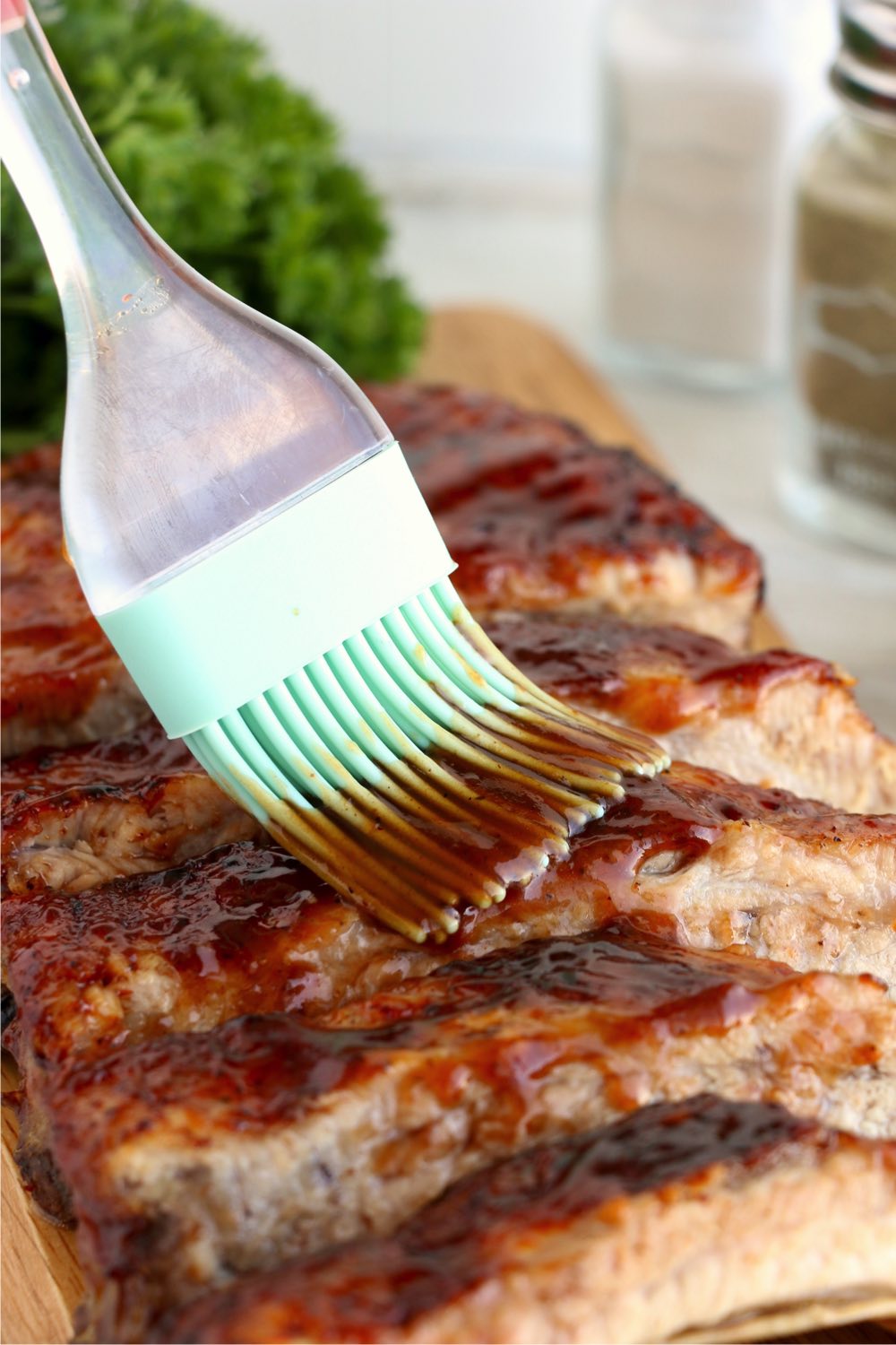brushing rack of ribs with BBQ sauce