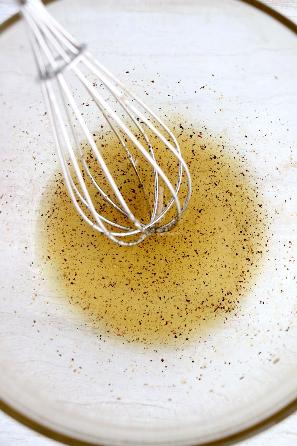 whisking oil and seasonings in bowl