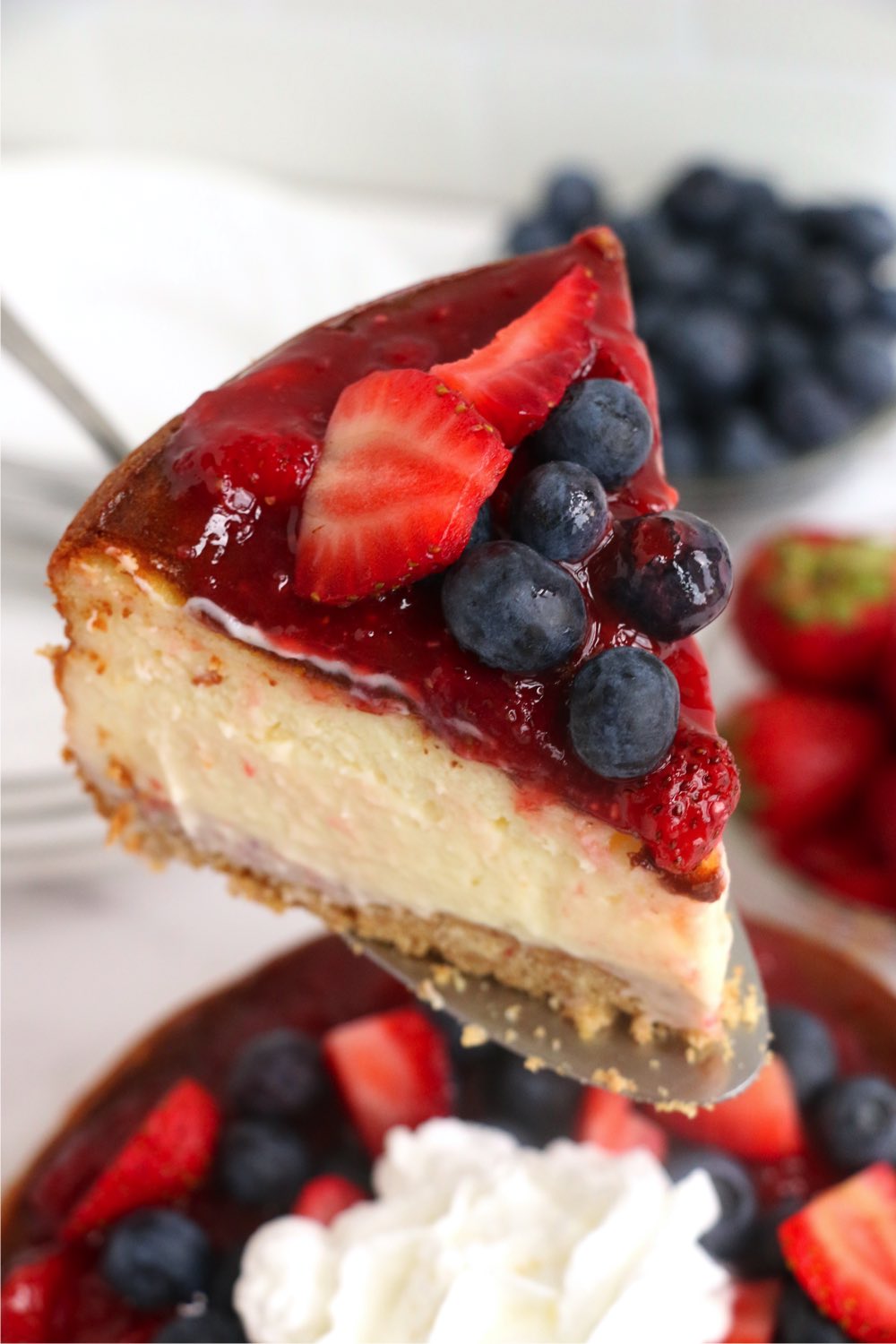 server holding piece of berry cheesecake