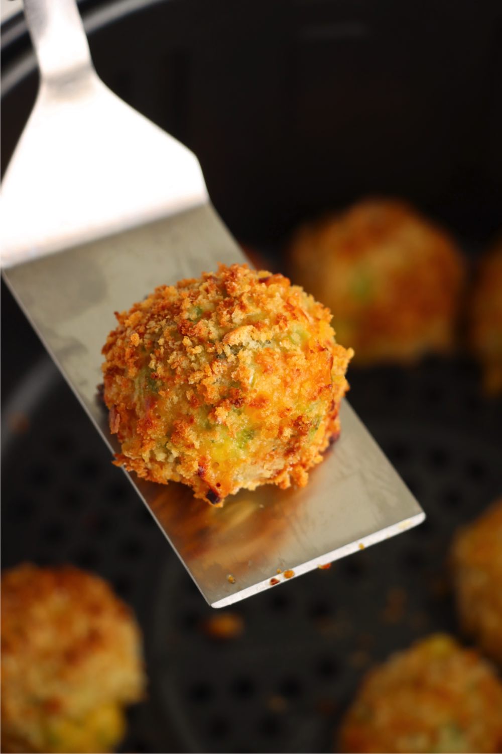 Spatula holding a broccoli cheese ball