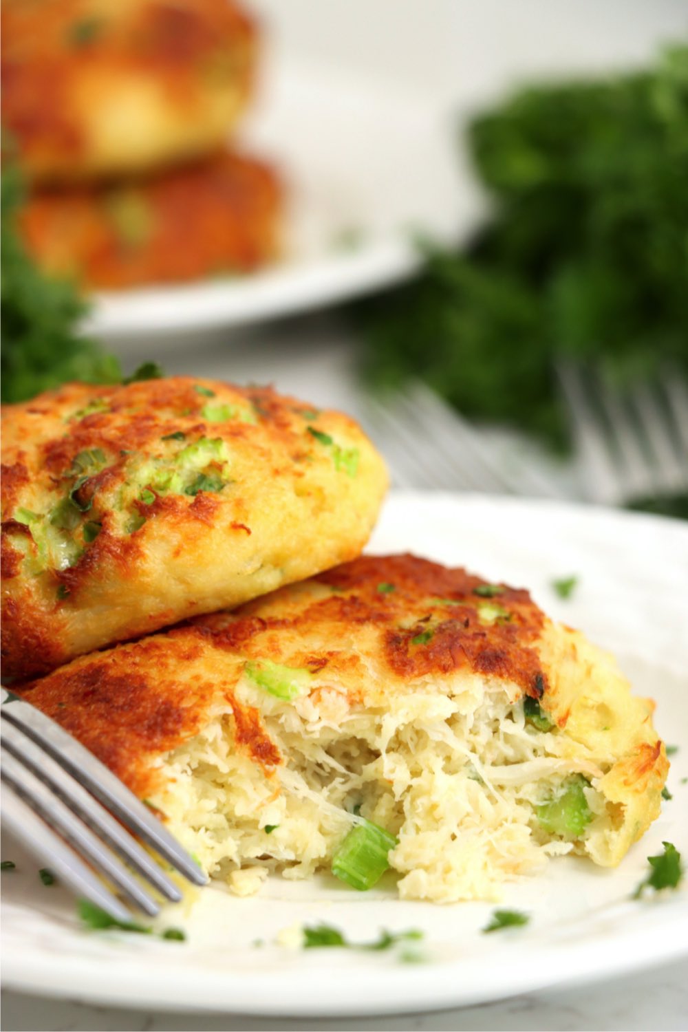 fork digging into a crab cake on a plate