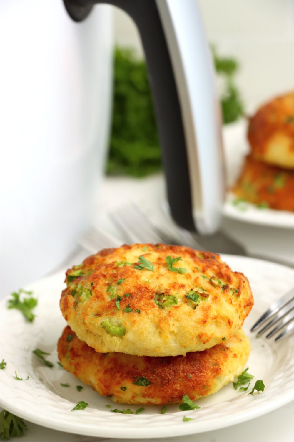 stack of crab cakes in front of air fryer