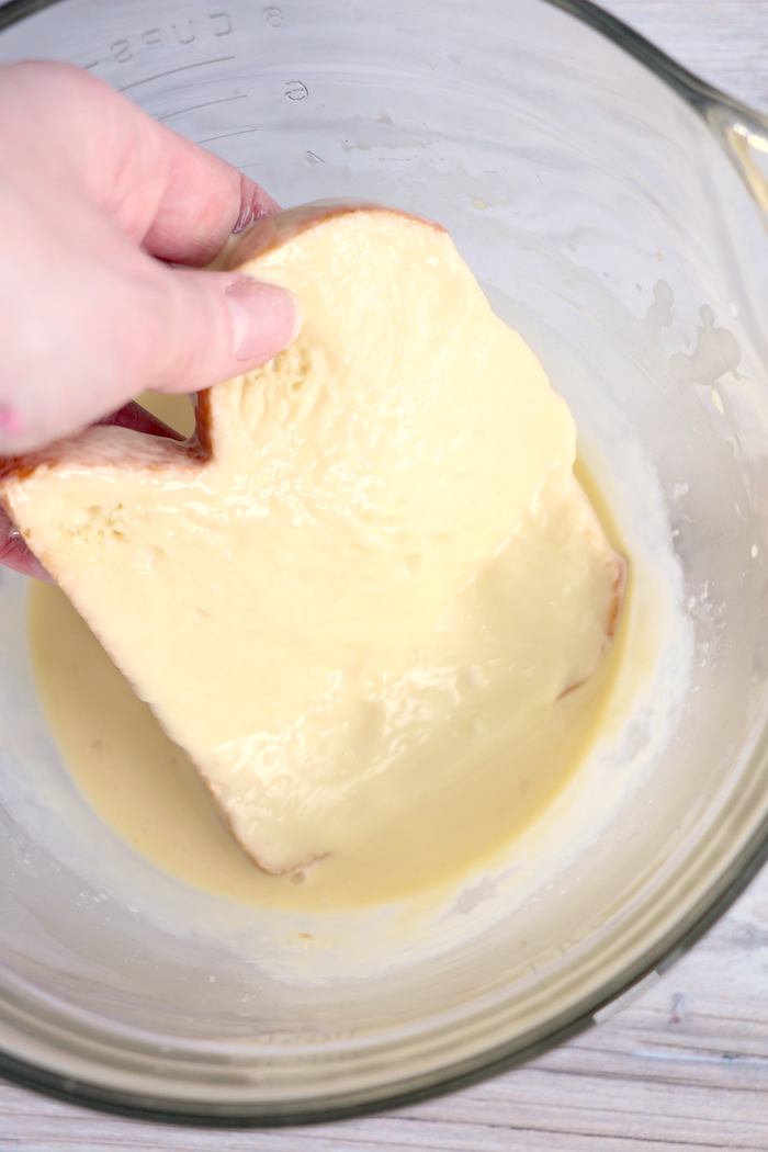 Dipping piece of brioche bread in egg mixture