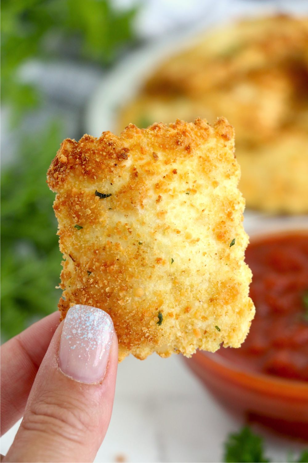 hand holding a piece of ravioli