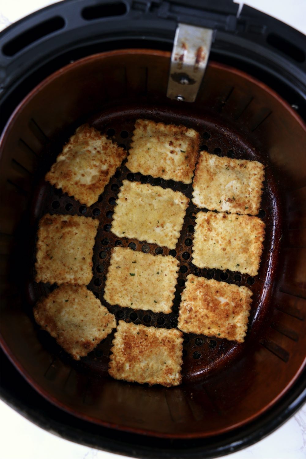 Toasted cheese ravioli in air fryer basket