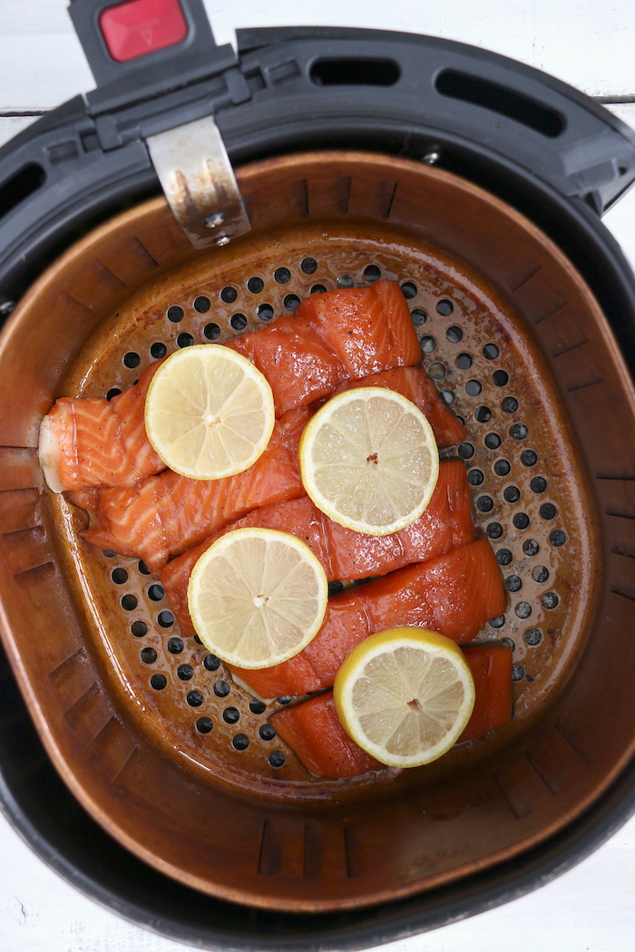 Salmon in an air fryer with lemon slices