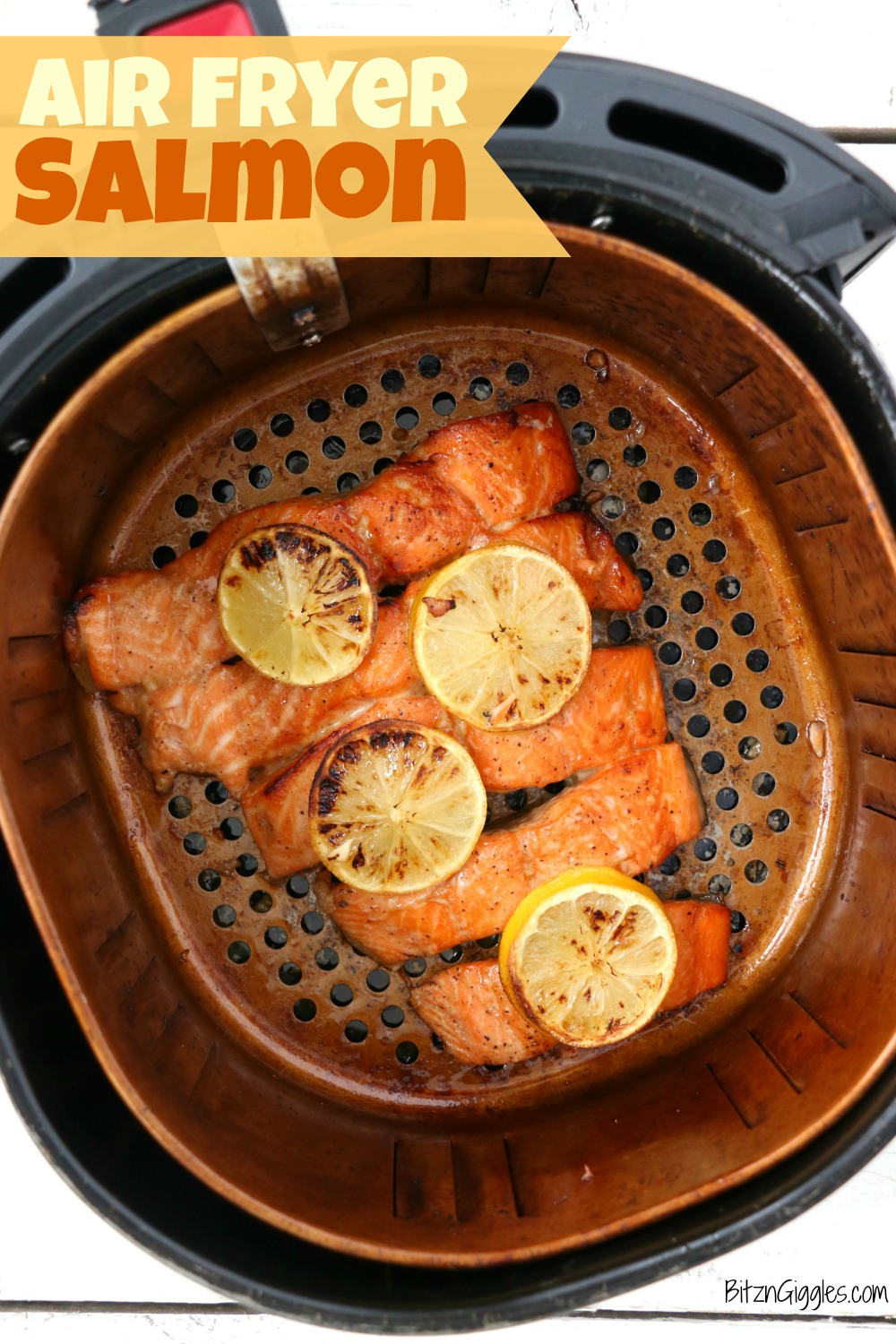 Salmon covered in lemon slices in air fryer basket