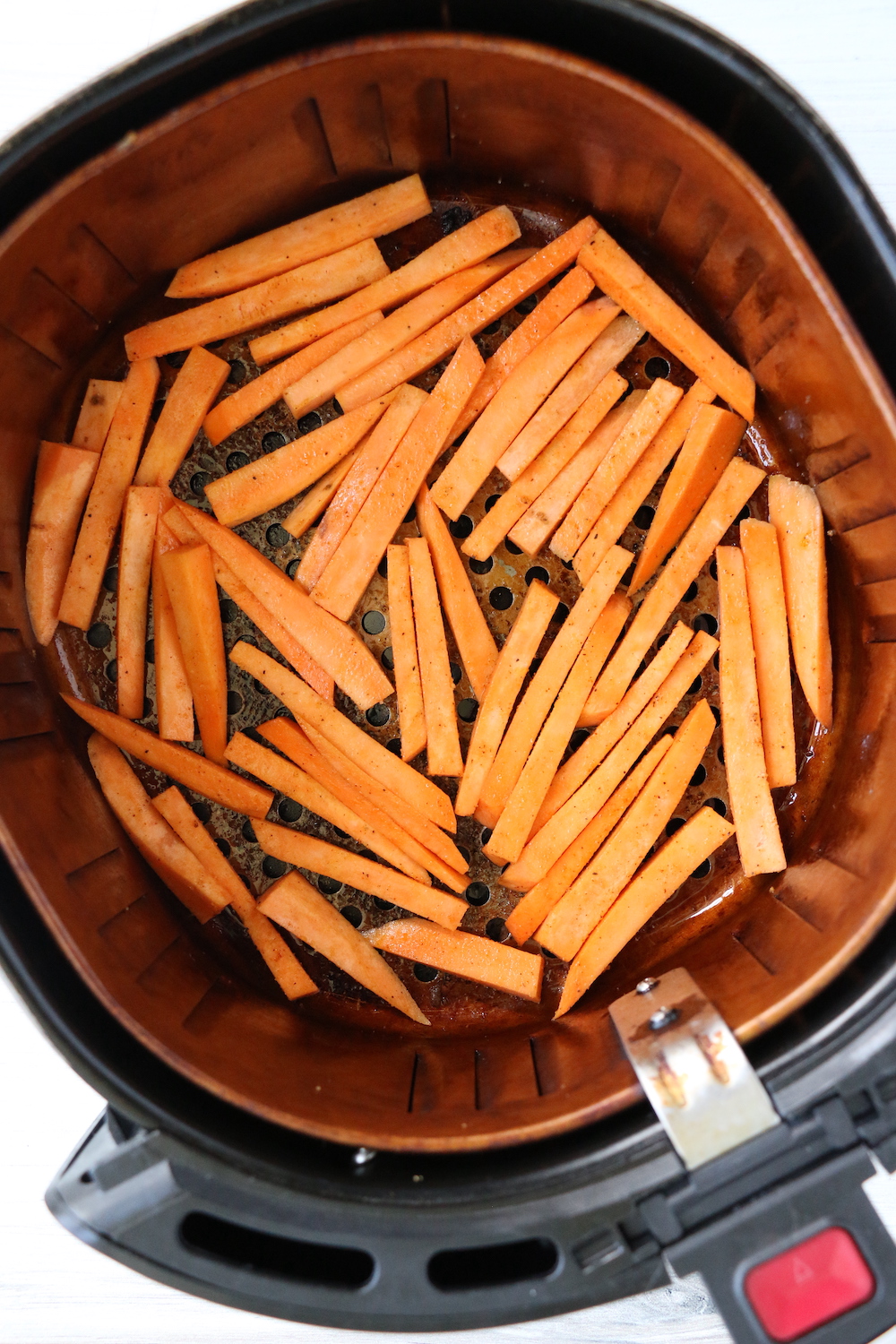 raw sweet potato fries in air fryer basket