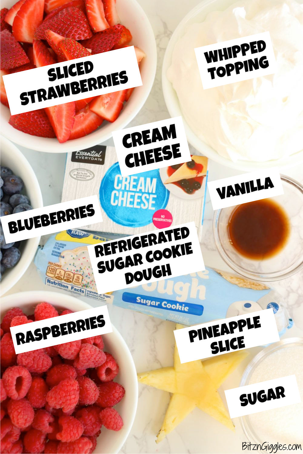 Ingredients for a fruit pizza laid out on a white table