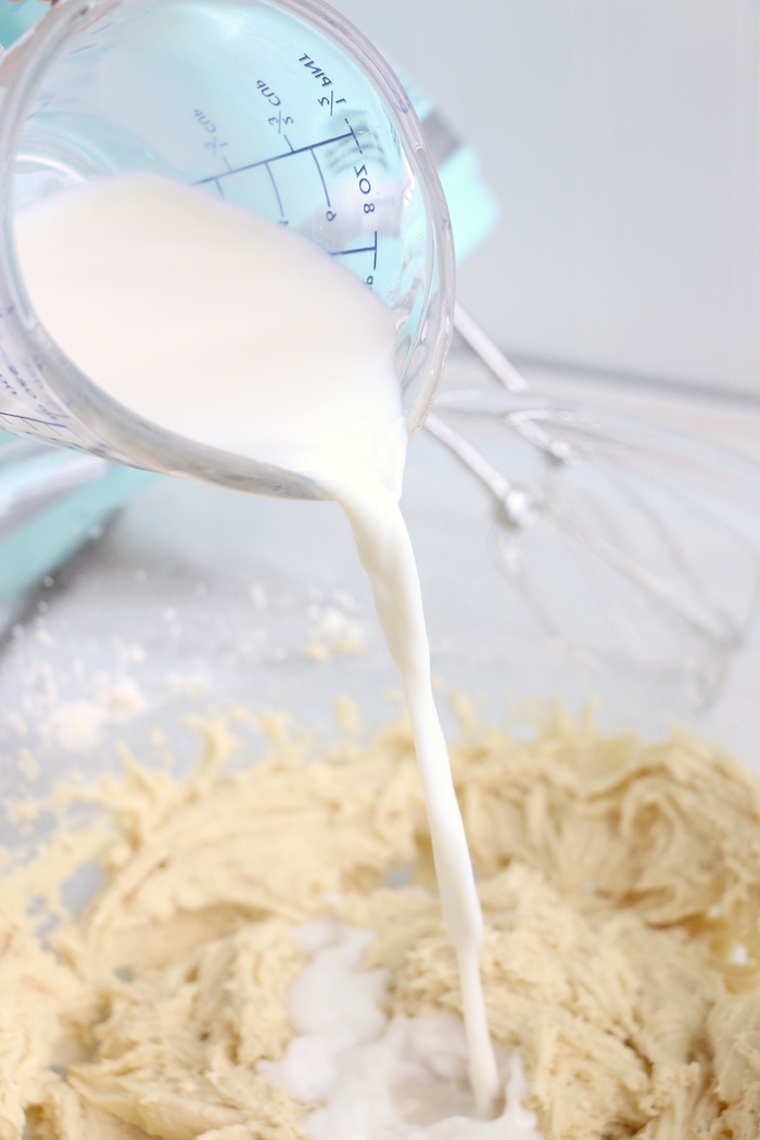 Pouring milk into a bowl of bread batter