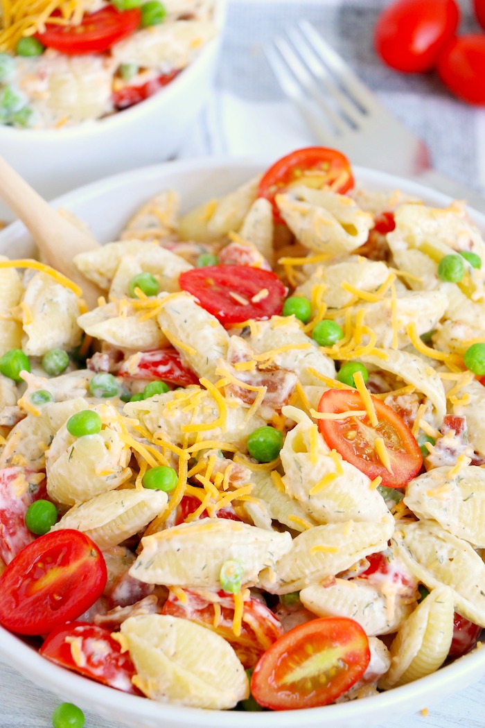 Wooden spoon in a bowl of pasta salad
