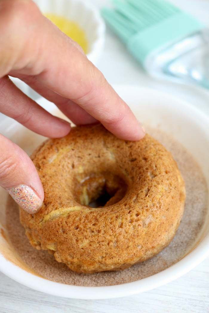 Dipping apples in cinnamon sugar mixture