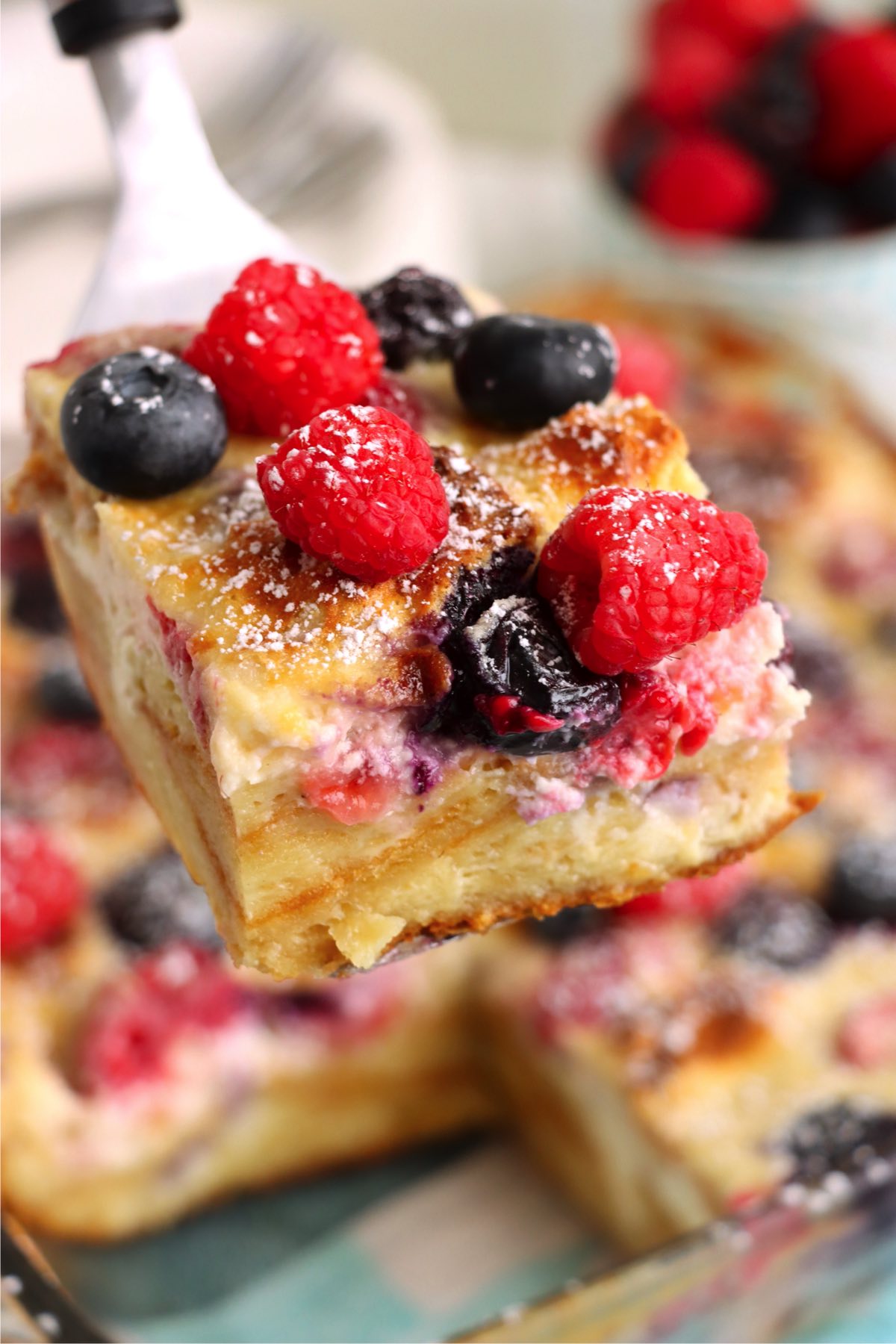 spatula holding piece of berry croissant casserole