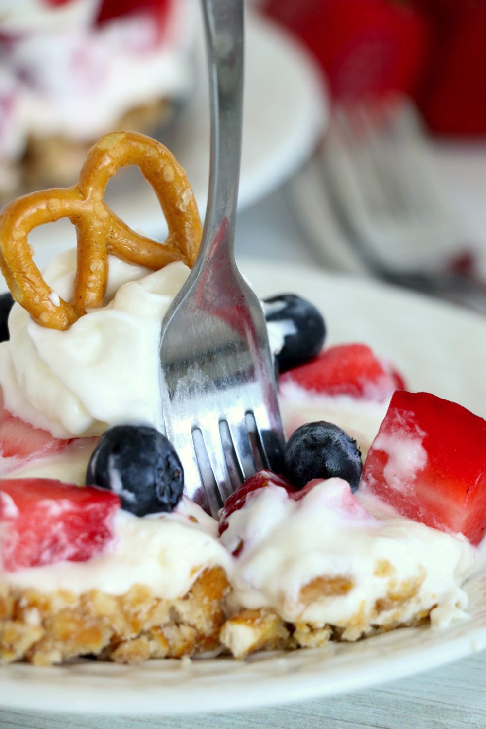 fork digging into berry pretzel dessert