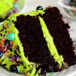 cut piece of chocolate layer cake with neon green frosting