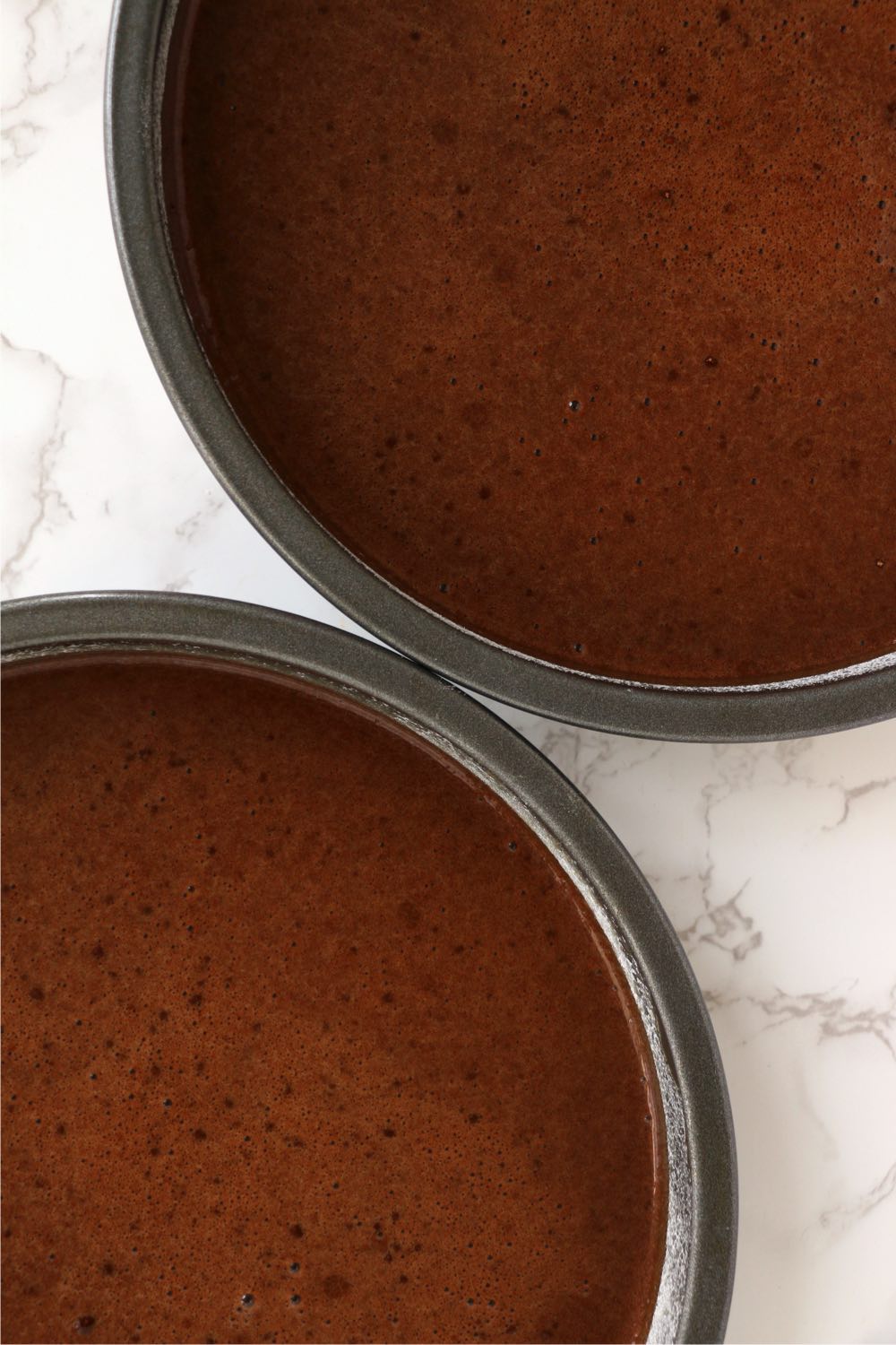 two cake pans filled with chocolate batter