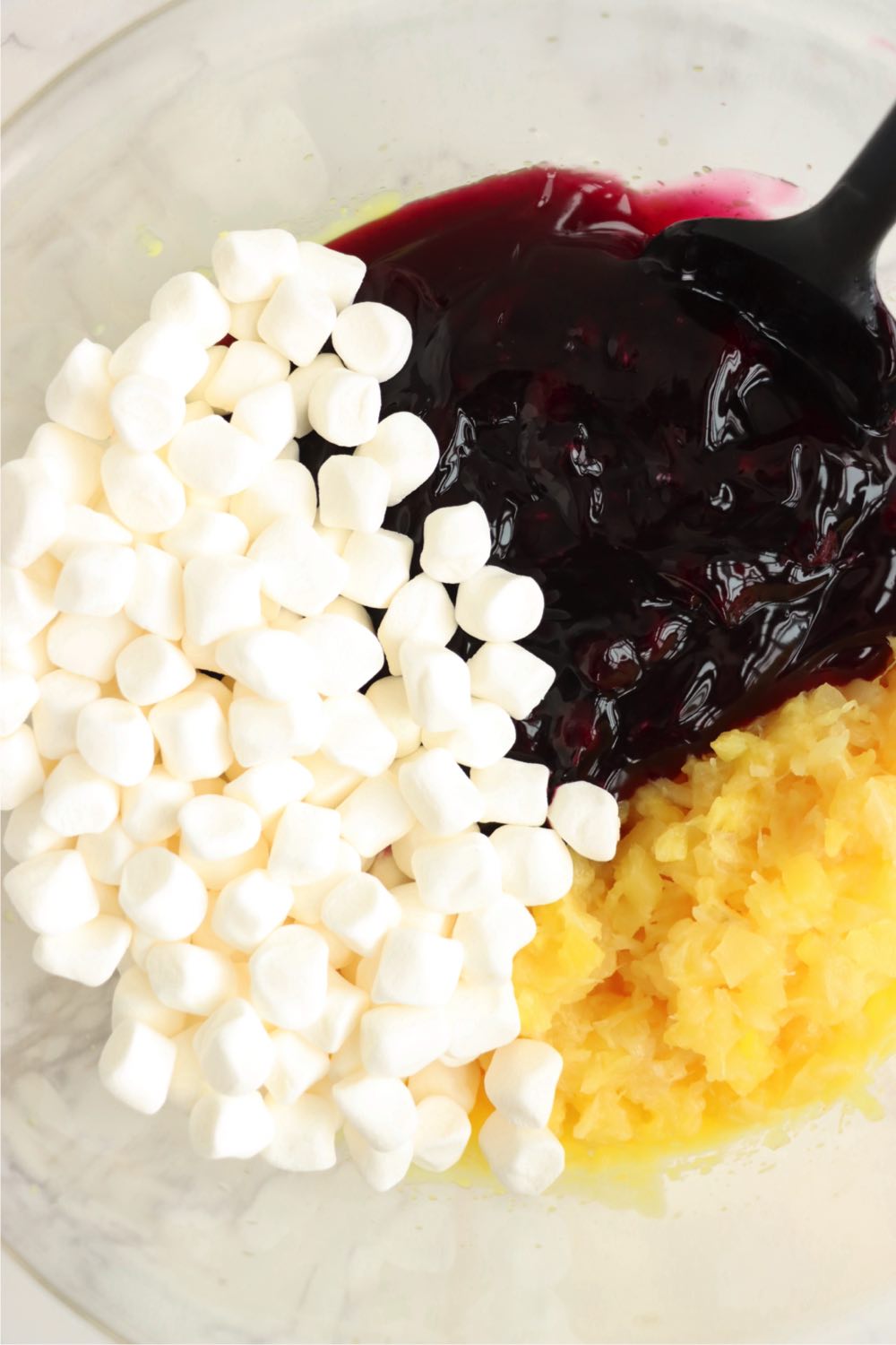 bowl filled with blueberry pie filling, marshmallows and crushed pineapple