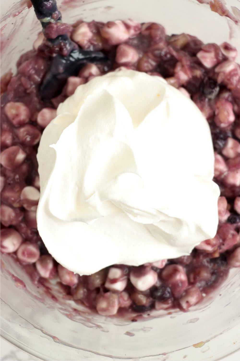 Adding whipped topping to a blueberry and marshmallow mixture