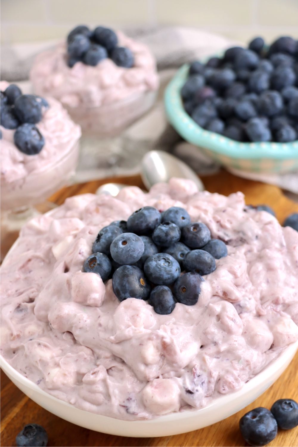 Large white bowl of blueberry fluff salad garnished with fresh blueberries