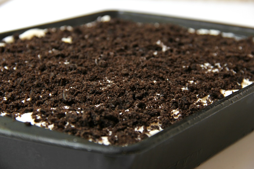 Buster Bar Lasagna - Decadent layers of Oreo cookies, ice cream, hot fudge, Snickers bars and whipped topping make up this delicious 5-layer dessert!