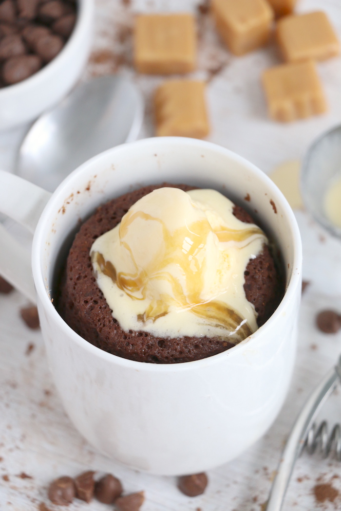 caramel and vanilla ice cream on top of chocolate mug cake