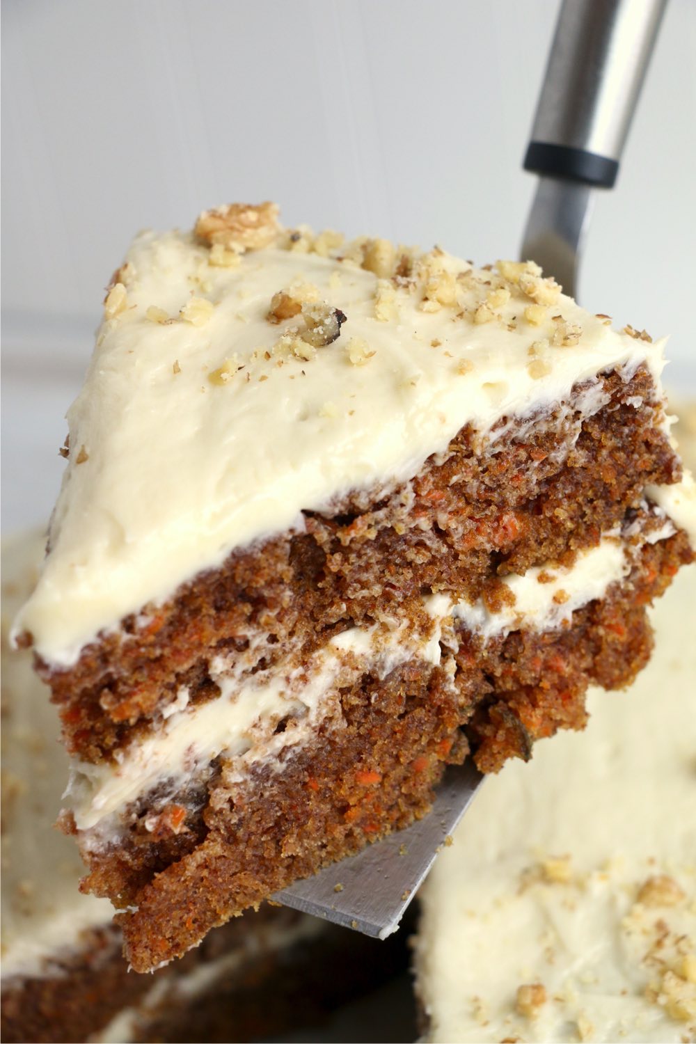 cake server holding piece of carrot cake