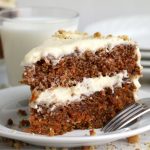 layered carrot cake on a plate with fork