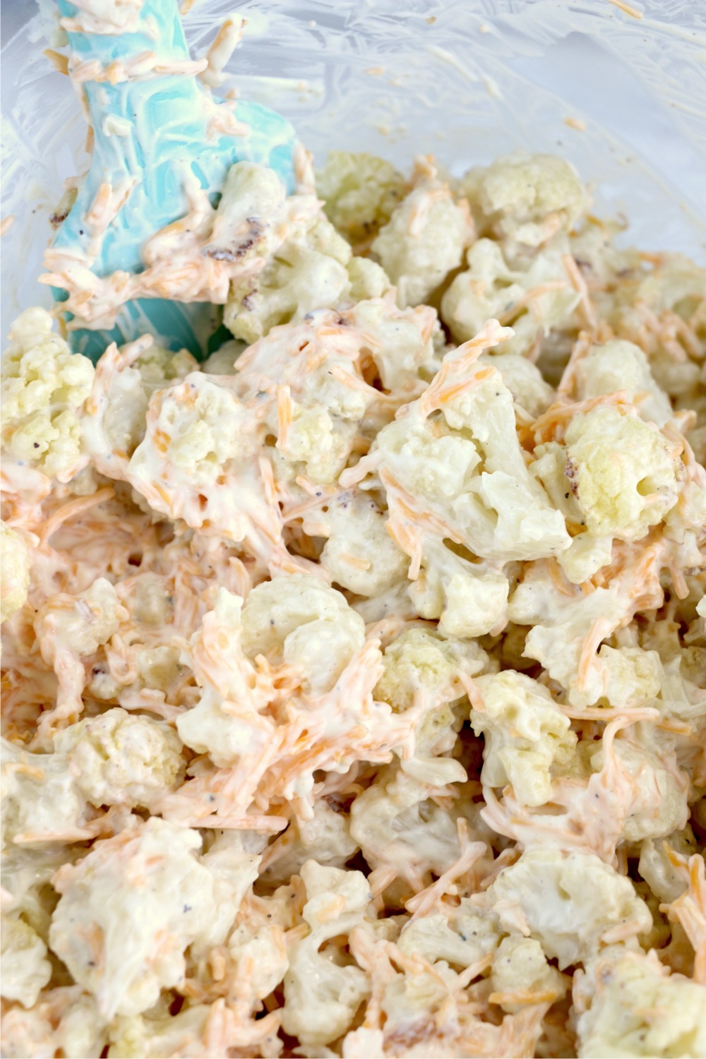 Mixing cauliflower florets with sour cream mixture
