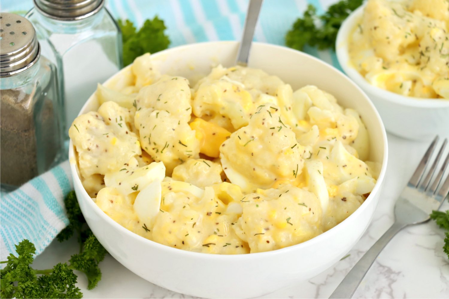 big white bowl of potato salad made with cauliflower