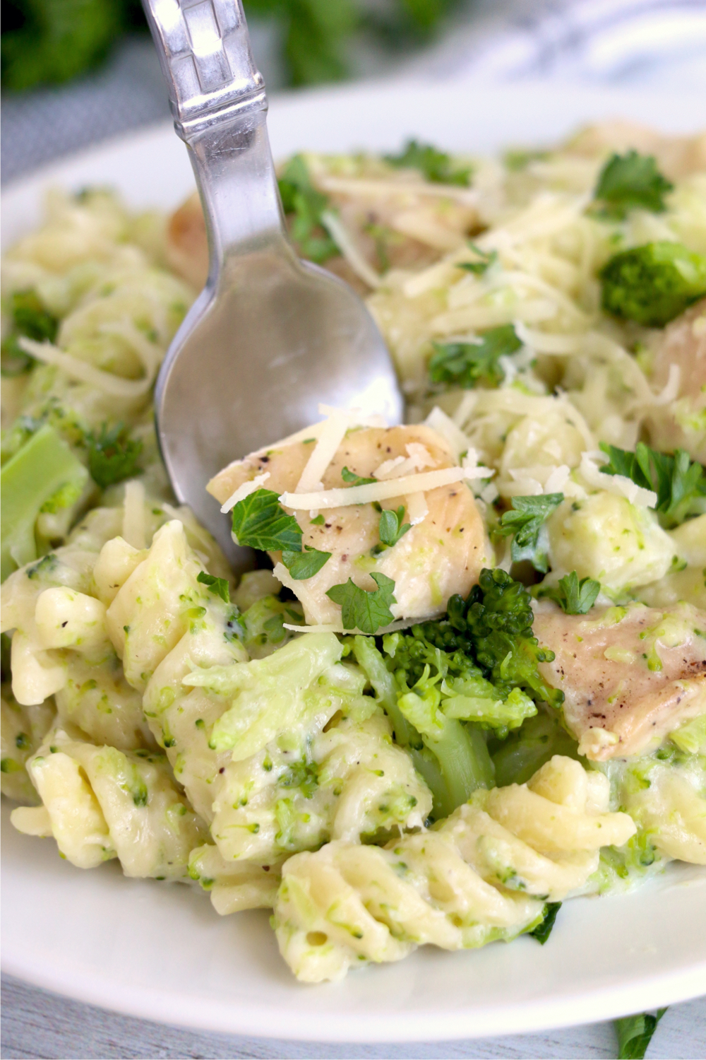 fork digging into chicken broccoli alfredo