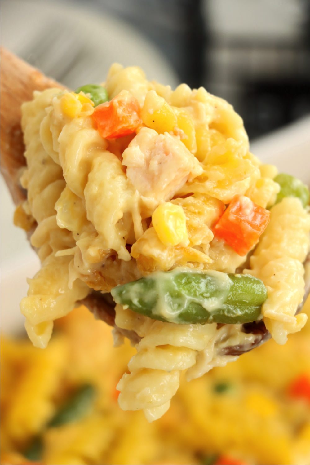 close up of a wooden spoonful of veggie pasta