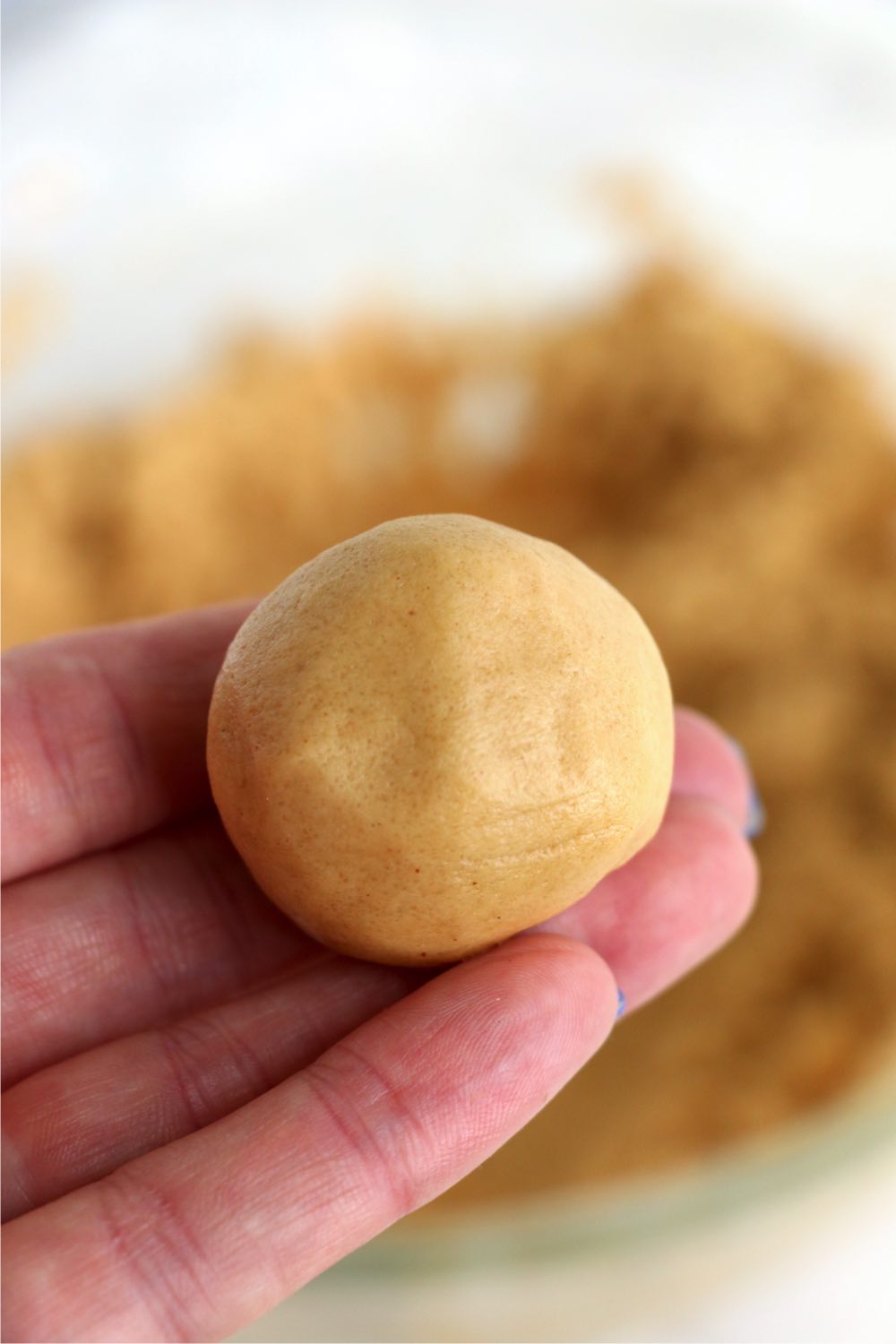 hand holding ball of cookie dough
