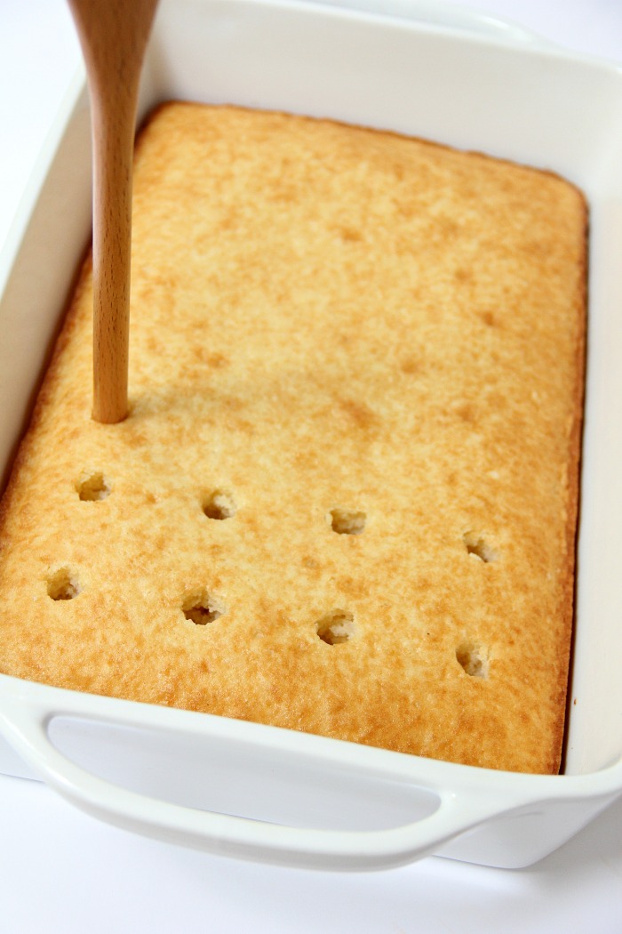 poking holes in cake with spoon handle