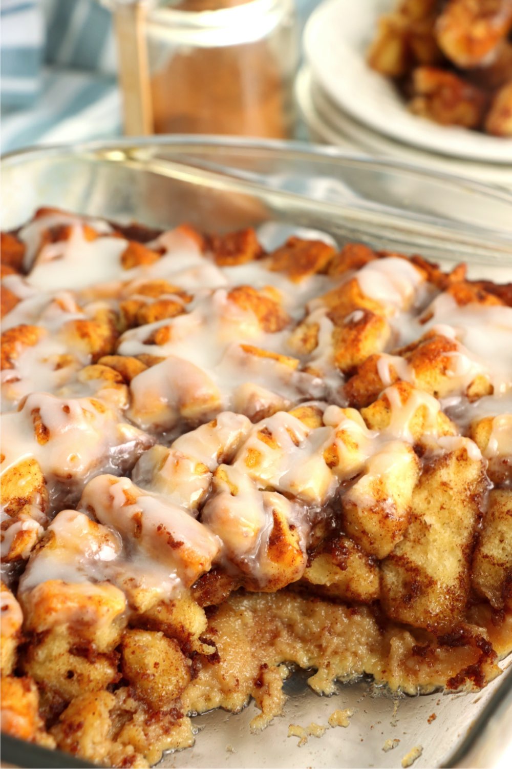scoop of cinnamon rolls taken out of casserole pan
