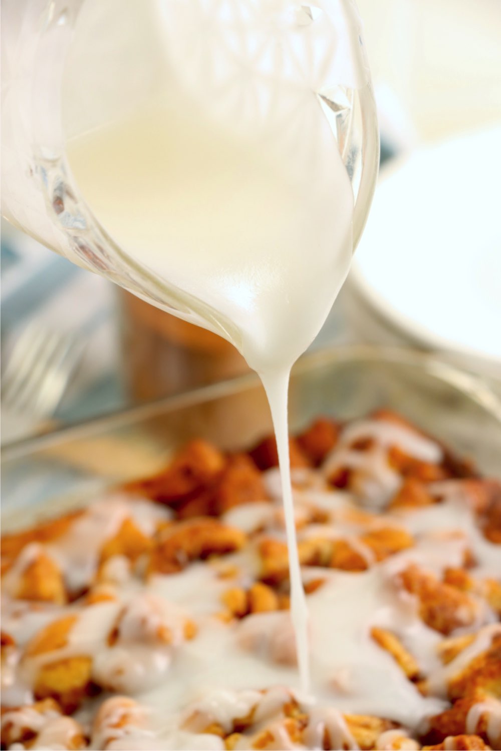 drizzling icing on cinnamon rolls