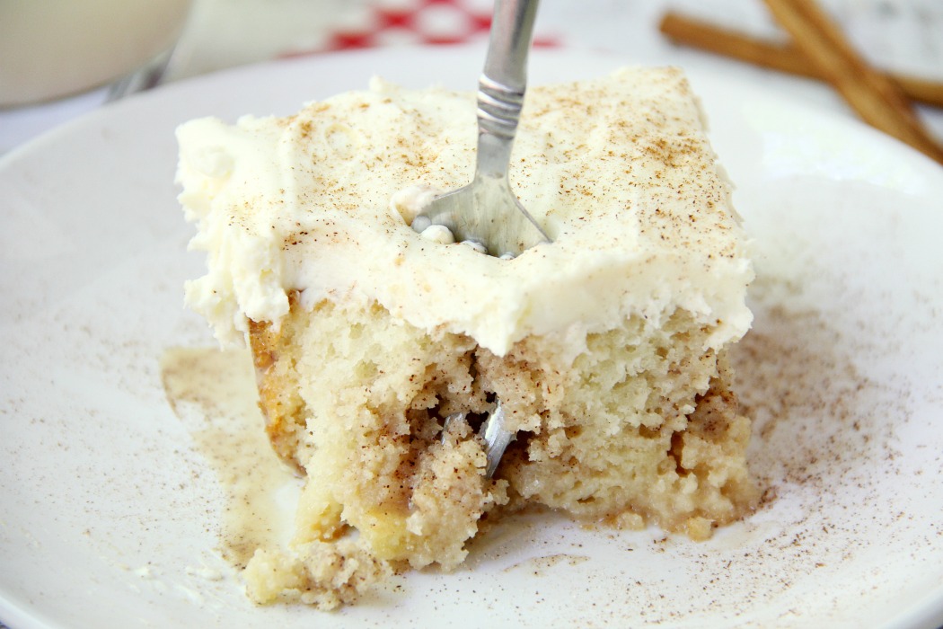 Cinnamon Roll Poke Cake - A soft and moist poke cake filled with a sweet cinnamon filling and topped with a homemade cream cheese frosting that melts in your mouth.