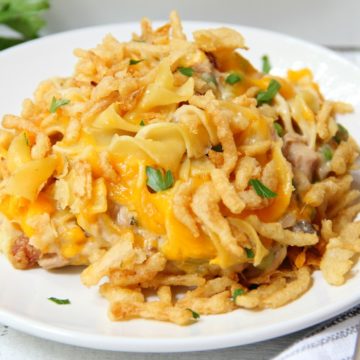 Classic Tuna Noodle Casserole - Ready in under 45 minutes, this classic and comforting casserole features tuna, onions, mushrooms, peas and cheese in a creamy sauce topped with more cheese and crunchy French fried onions! So flavorful, and sure to satisfy the entire family!