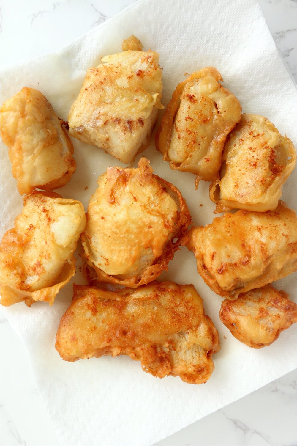 fried fish sitting on paper towel