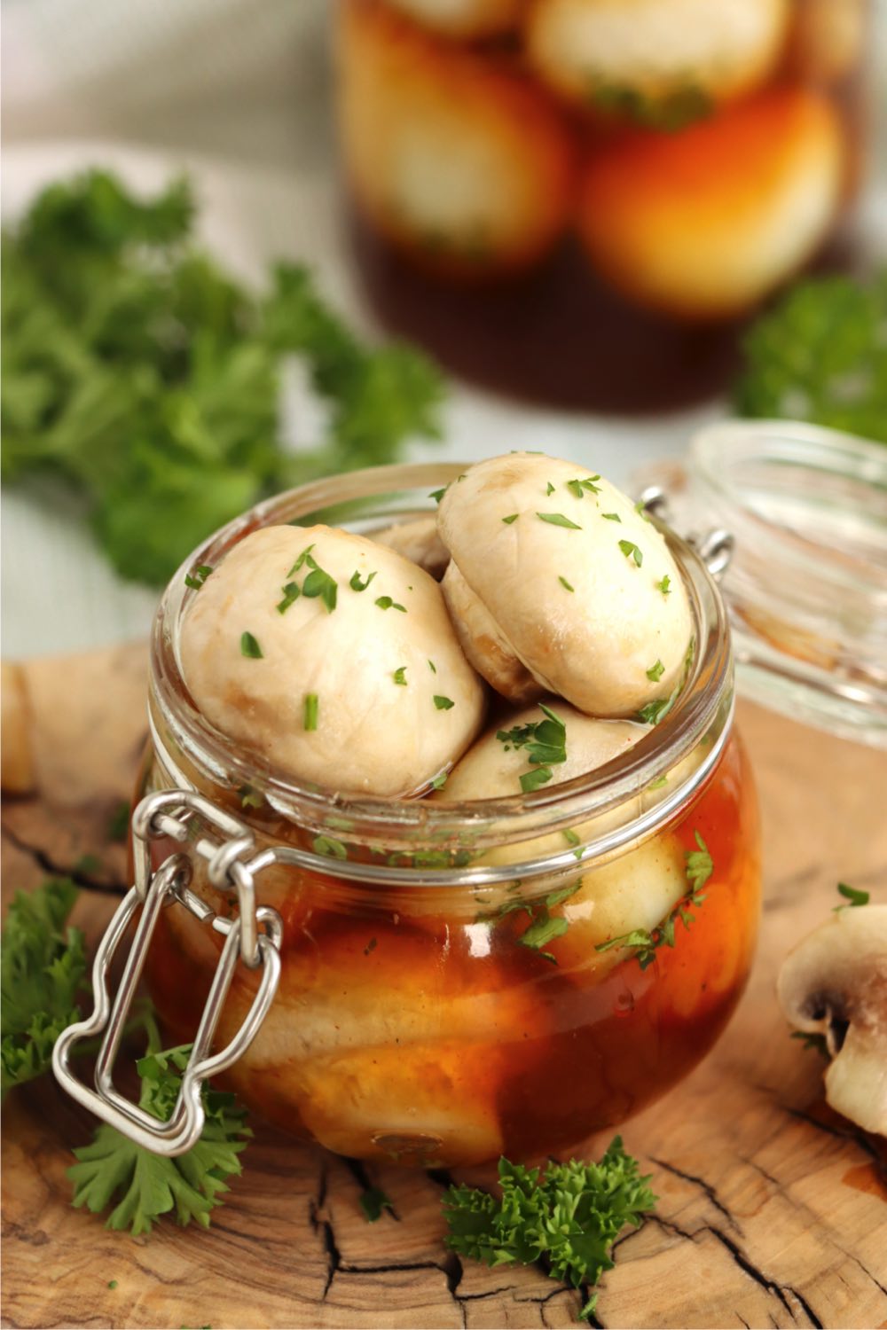 Small glass pint container filled with cocktail mushrooms garnished with parsley
