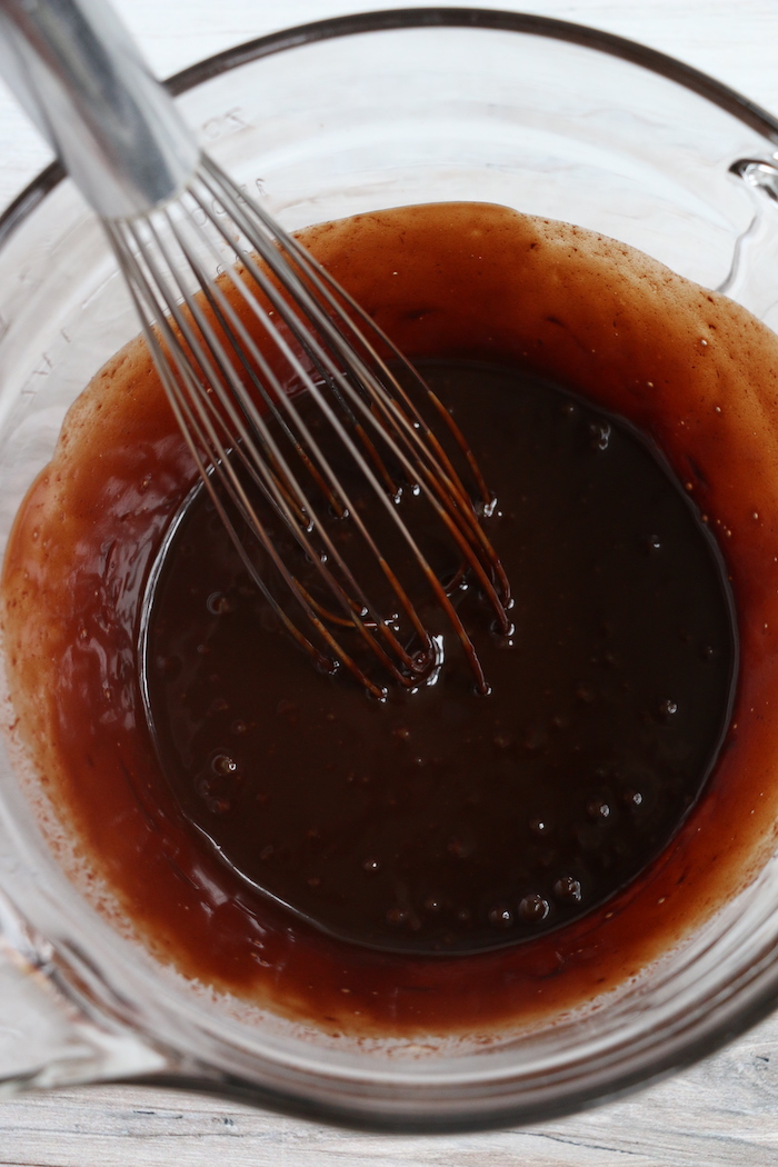 mixing fudge in a bowl for ice cream cake
