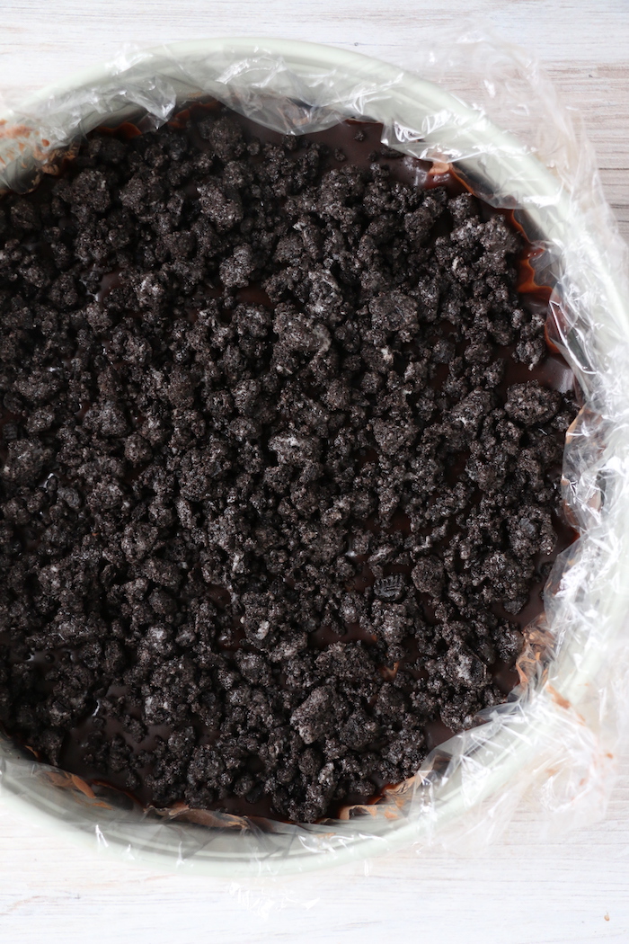 Oreo cookie crumbs on top of fudge layer of ice cream cake
