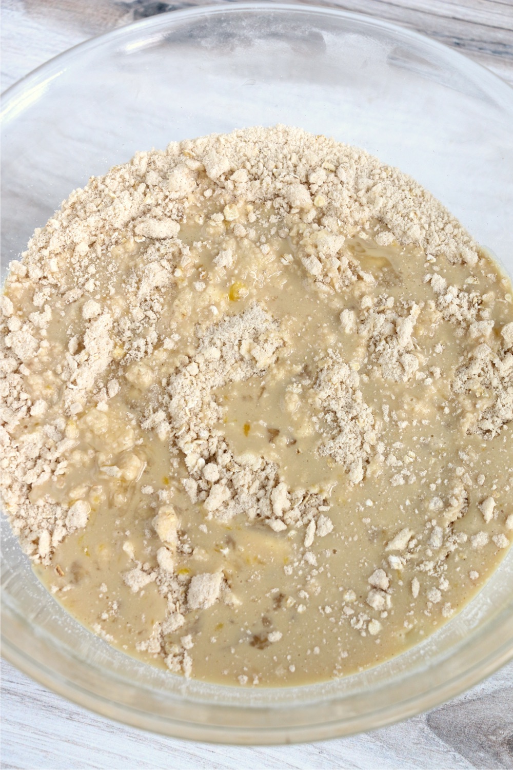 Adding wet ingredients to dry crust ingredients in glass bowl