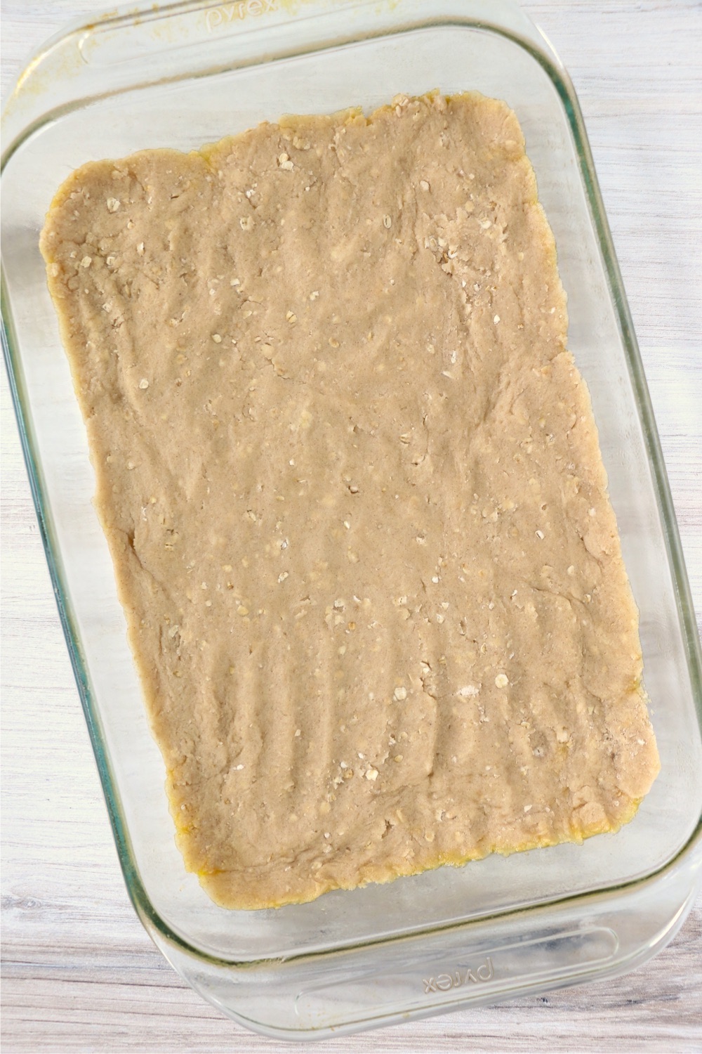 Crust pressed into the bottom of a glass baking dish