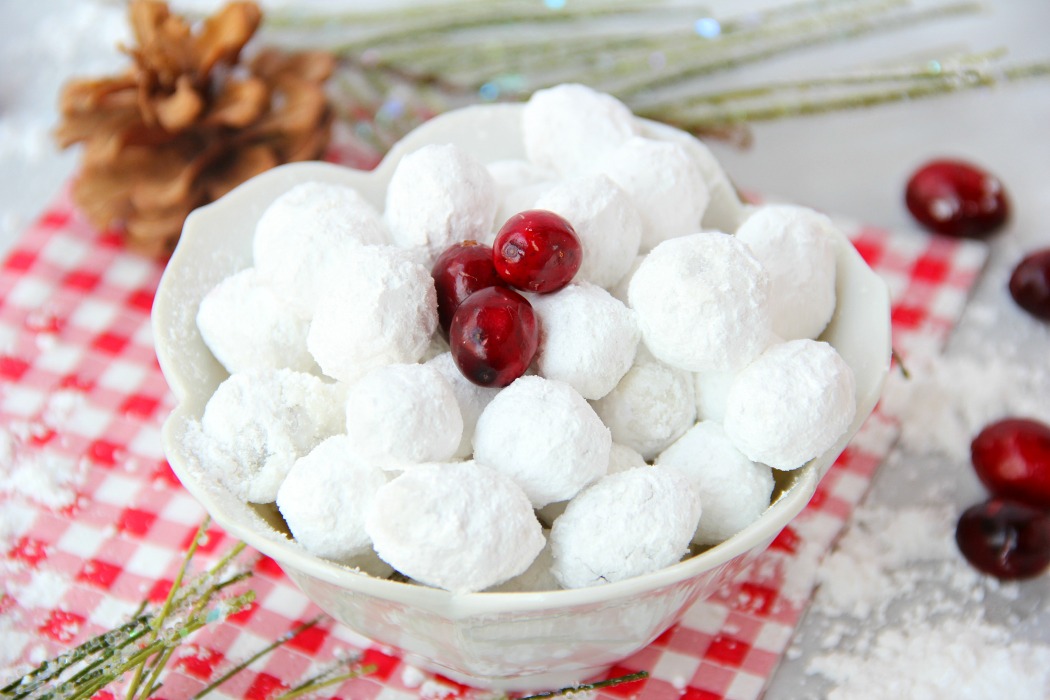 Cranberry Snowballs - Fresh cranberries rolled in powdered sugar then baked and chilled. Surprise your guests with a burst of delicious cranberry when they bite into these sweet and tangy confections!