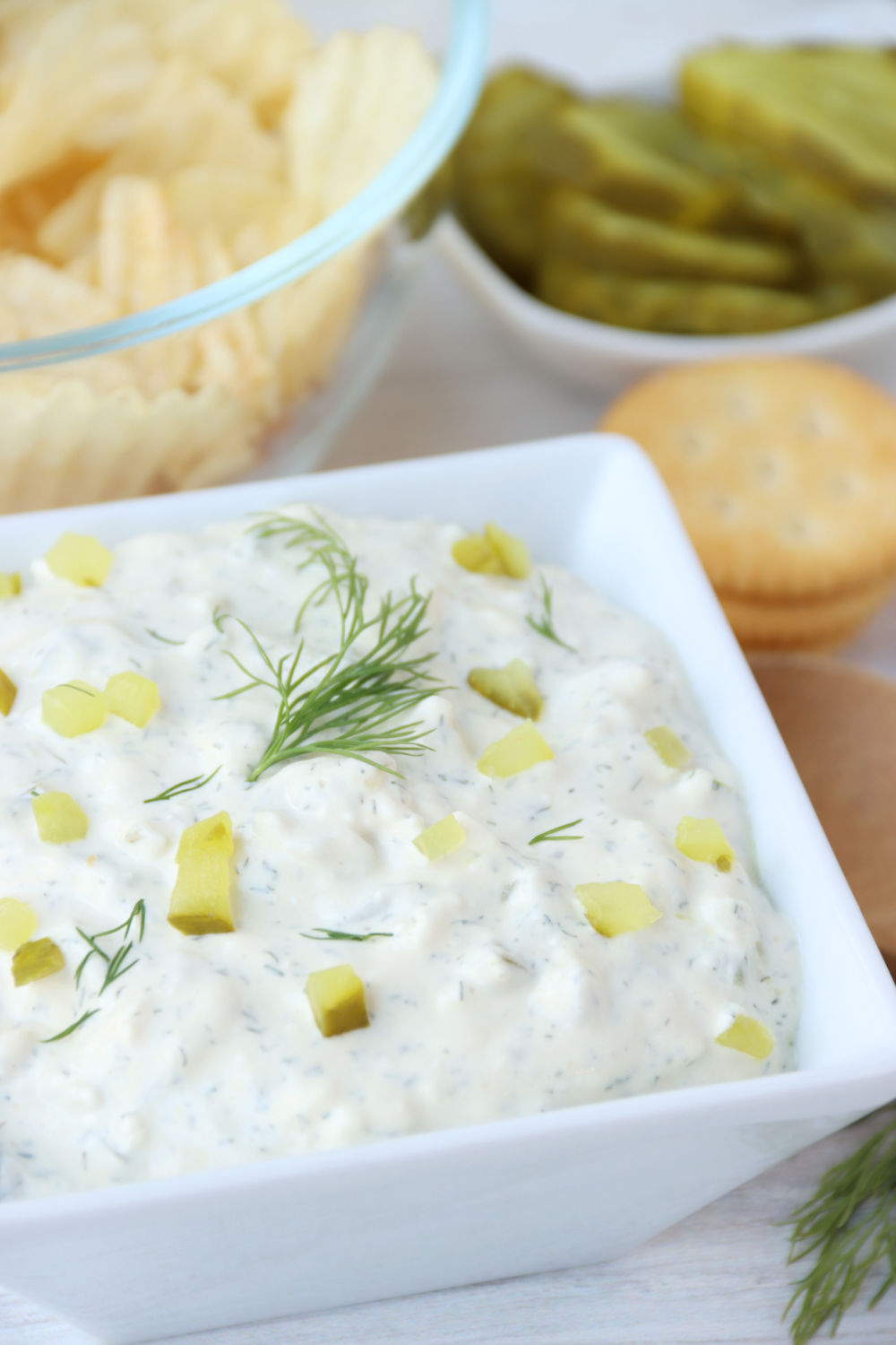 bowl of dill pickle dip with crackers in background