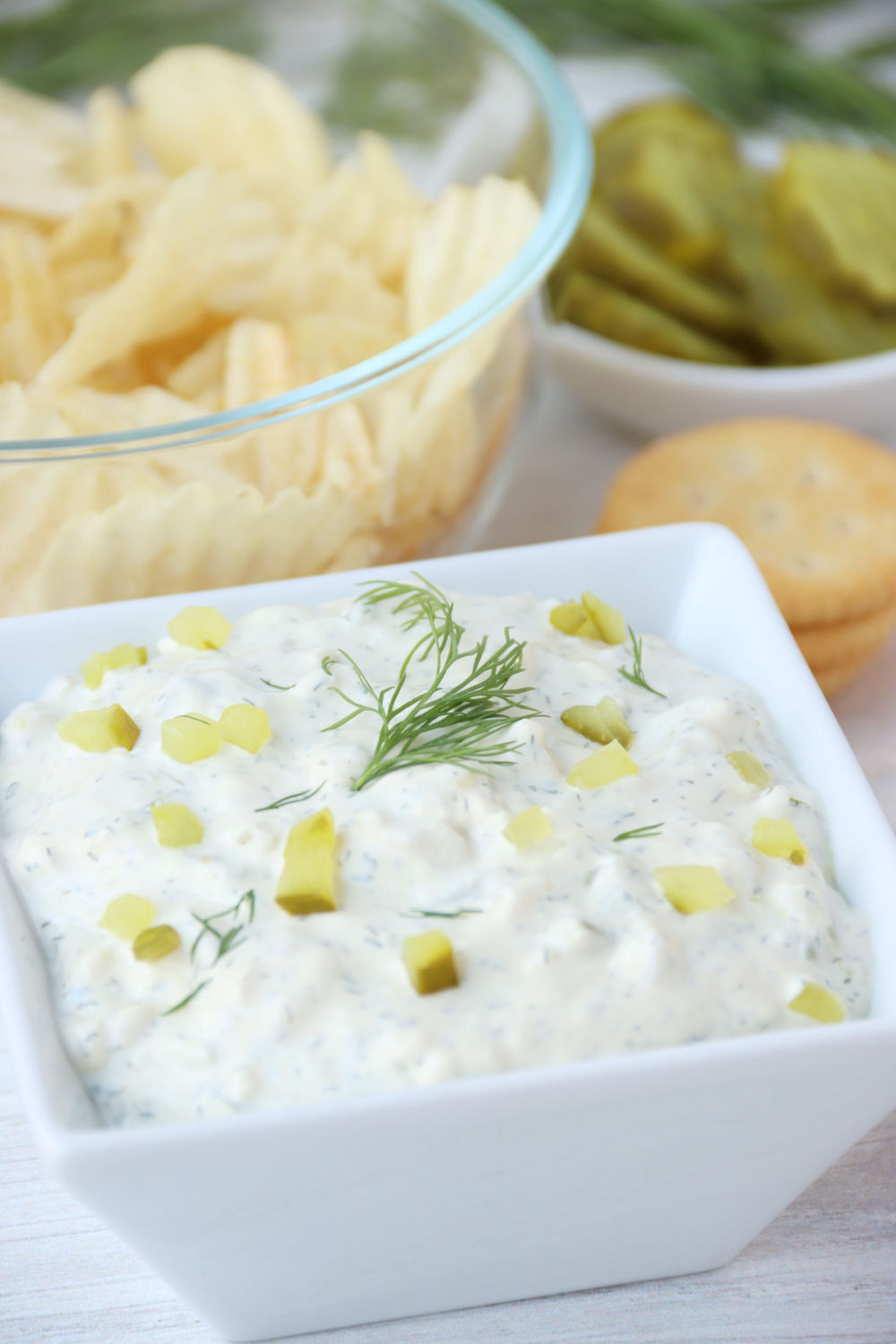 dill pickle dip with chips and crackers in the background