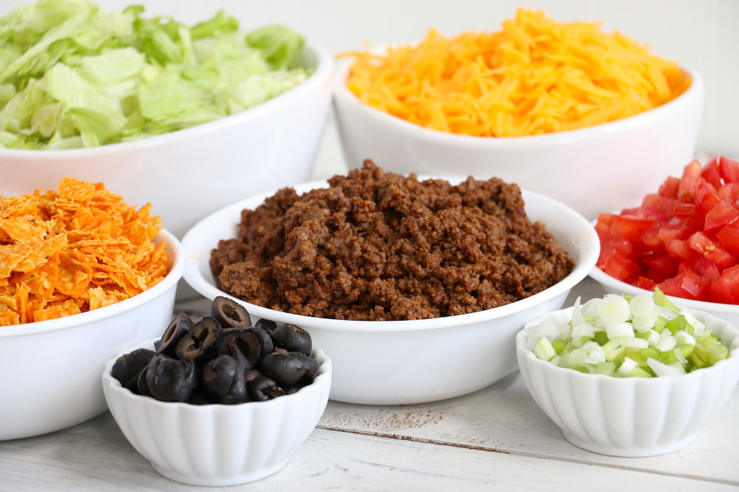 Dorito Taco Salad - This crunchy and zesty salad is made with seasoned ground beef, veggies, cheese and Doritos, then tossed with Catalina dressing. So delicious and serves a crowd!