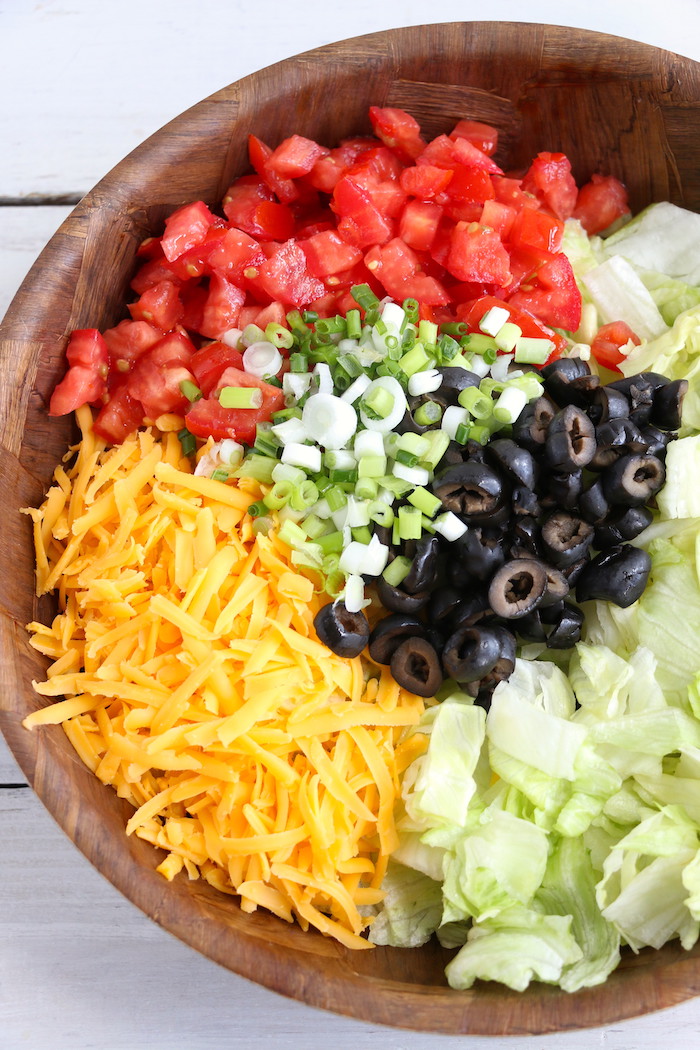 Dorito Taco Salad - This crunchy and zesty salad is made with seasoned ground beef, veggies, cheese and Doritos, then tossed with Catalina dressing. So delicious and serves a crowd!